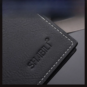Close-up of litchi texture black leather wallet with white double stitching and embossed logo