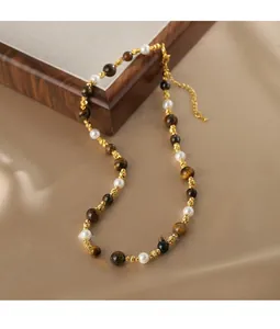 Détail des perles d'oeil de tigre et des perles dorées sur un collier rétro