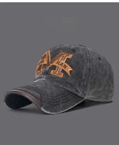 Close-up of vintage washed cotton baseball cap with orange embroidered letter M design