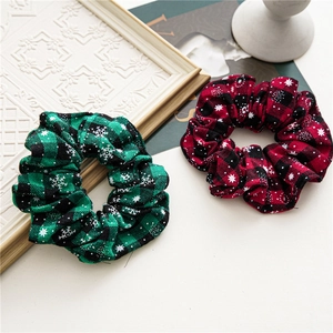 Detail of red and green plaid Christmas scrunchies with white snowflake patterns