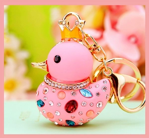 Close-up of pink rhinestone duck keychain with a golden crown and sparkling jewels