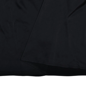 Détail des coutures et de la texture de la robe longue dos nu en satin noir