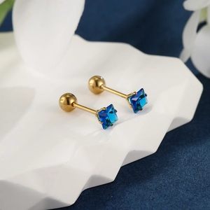 Macro shot of square blue gemstones on golden earrings with secure screw-on spherical backs