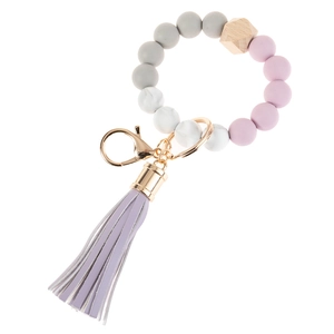 Close-up of silicone beaded keychain with hexagon wood bead and purple leather tassel