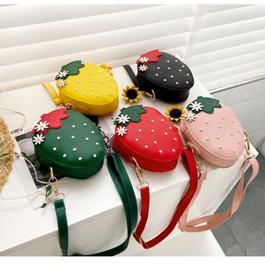 Detail view of colorful strawberry PU leather shoulder bags with gold rivets and flowers