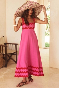 Close-up of pink maxi dress featuring detailed red scalloped trim on the bodice and hemline