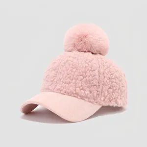 Detailed view of pink fuzzy kids baseball cap with soft faux fur pompom and textured fabric