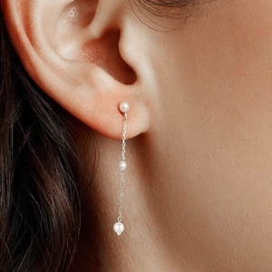 Detail of s925 silver tassel chain pearl earrings shown on a model for elegant style