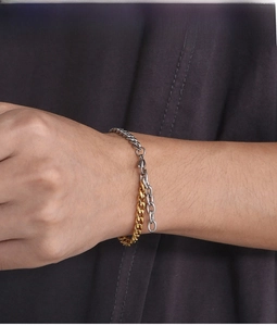 Close-up of two-tone gold and silver Cuban link chain bracelet on a model's wrist