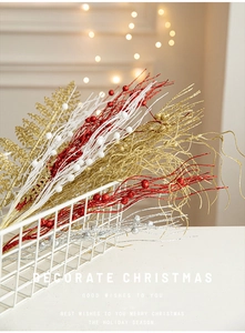 Close-up of glittered Christmas berry branches in red and gold in a metal basket