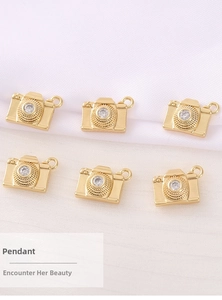 Macro view of gold-plated camera charms with zircon inlay for DIY jewelry making