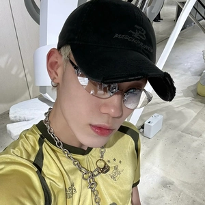 Close-up of Y2K star rimless sunglasses with street style gold jersey and accessories