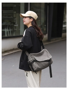 Side view of gray canvas messenger bag with adjustable black strap on a model