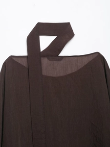Detail of dark brown semi-transparent fabric texture on a casual rivet poncho top