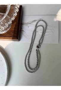 Detail of gray glass pearls with a square mother-of-pearl clasp and pavé rhinestones