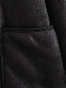 Détail de la texture cuir noir et coutures renforcées sur la poche de la veste