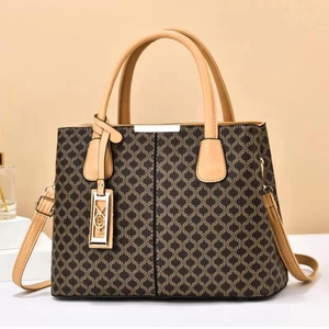 Large capacity printed handbag in brown and khaki with crossbody strap on warm background