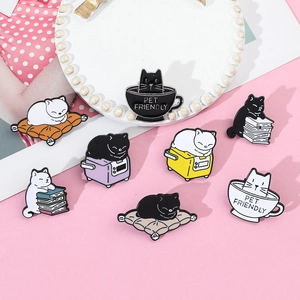 Detail view of cute enamel cat pins on a tray featuring kittens on books and in cups