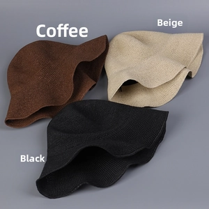 Detail von handgewebten Strohhüten in Kaffee, Beige und Schwarz mit faltbarer Textur