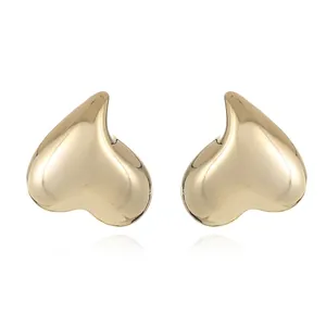Macro shot of mirror-polished gold-plated teardrop earrings with elegant reflections
