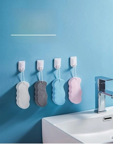 Detailed view of 3D bath sponges in four colors hanging on hooks in a bathroom