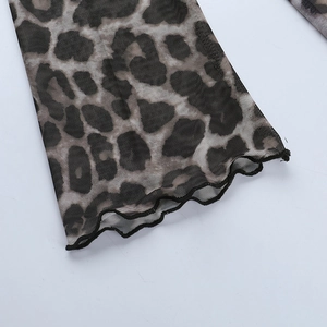 Détail du tissu en maille imprimé léopard avec bordure ondulée et couture de précision