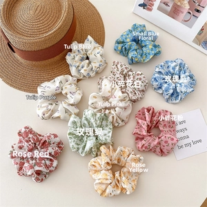 Flat lay of colorful floral scrunchies with tulips and roses on a rustic table