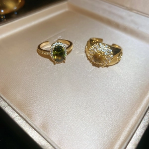 Macro detail of 18k gold plated tiger eye and zircon rings in a silk jewelry box