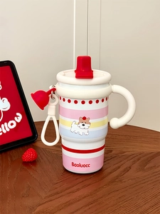 Detail of cartoon coffee mug with ceramic liner on wooden desk with straw accessory
