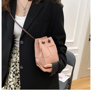 Detail of pink woven bucket bag showing the texture and stylish crossbody fit for women