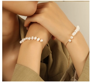 Gros plan d'un bracelet en perles d'eau douce naturelles en acier doré 18K sur le poignet