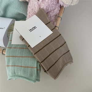 Detailed knit texture of Morandi striped crew socks inside a decorative basket