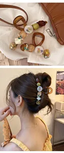Détail d'une pince à cheveux vintage coréenne avec fleurs séchées et perles d'ambre