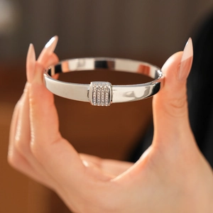 Gros plan du bracelet en acier titane argenté avec détails de diamants pavés rectangulaires