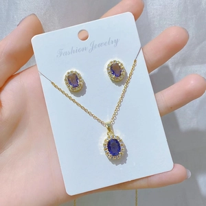 Detailed view of a gold jewelry set with oval purple gems and sparkling rhinestones