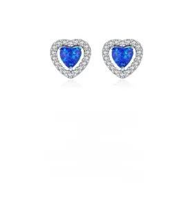 Détail des boucles d'oreilles cœur en argent avec opale bleue et halo de zircon