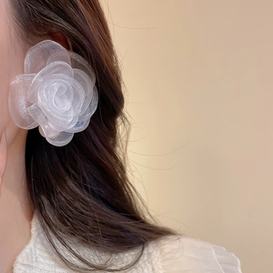 Close-up of elegant large white organza rose earring with delicate layered petals