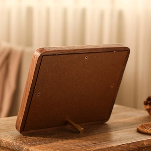 Detailed back view of walnut wood frame showing brass support rod and smooth grain