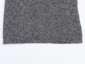 Macro detail of grey wool blend fabric showing intricate knit texture and fiber density