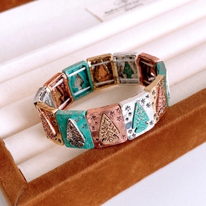 Detail of vintage stretch tile bracelet with Christmas tree patterns and colorful metal finish