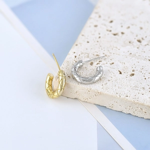 Textured C-shape hoop earrings in gold and silver finish with quilted pattern