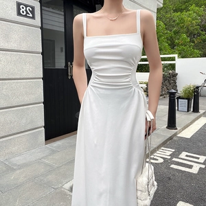 Detail showing the pleated waist design and white fabric of the elegant long dress