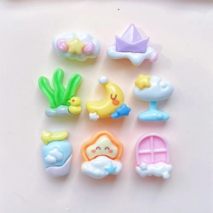 Flat lay of colorful resin mini charms featuring clouds, stars and cartoon ducks for DIY crafts