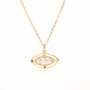 Gold plated evil eye pendant necklace with pearls and zircon stones on white background