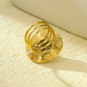 Close-up of 18K gold textured round ring with triple-band design and pearl setting