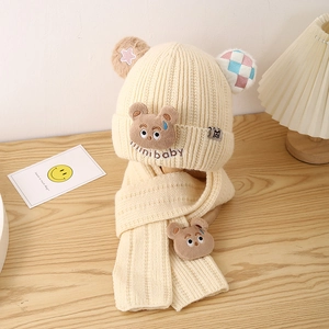 Detail of cream knit baby winter set with cute bear patches and mini baby embroidery