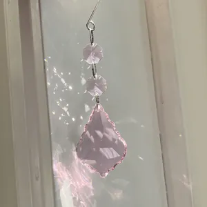 Pink suncatcher crystal pendant with faceted beads reflecting rainbow light on white window