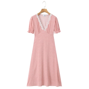 Detailed view of pink polka dot dress featuring elegant white lace trim and V-neckline