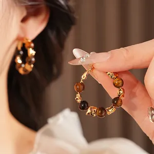 Boucles d'oreilles créoles dorées en œil de tigre au design vintage et raffiné