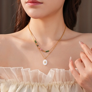 Detail of double-layer golden necklace with colorful beads and star mother of pearl pendant